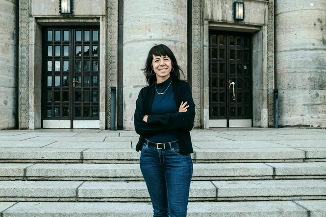 Porträt von Elif Eralp - sie steht vor der Volksbühne in Berlin