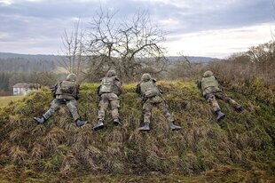 Vier Soldaten in herbstlicher Landschaft