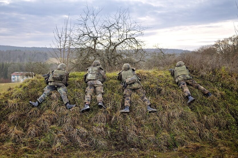 Vier Soldaten in herbstlicher Landschaft