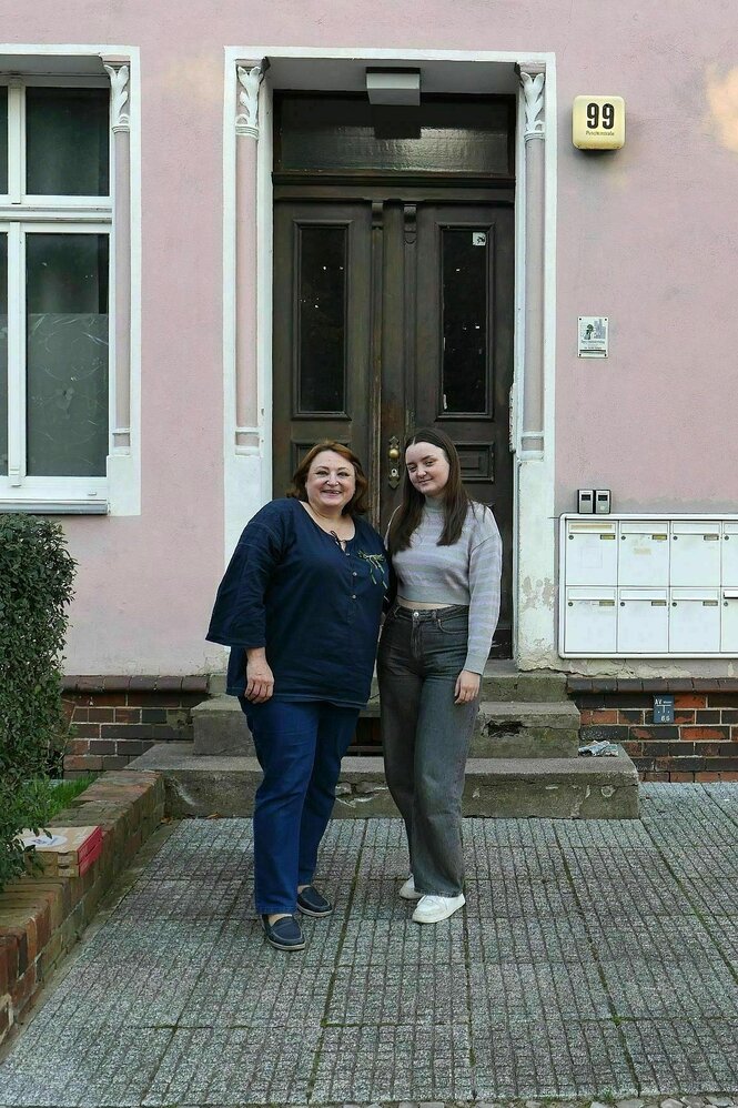 zwei Frauen stehen vor einer Haustür