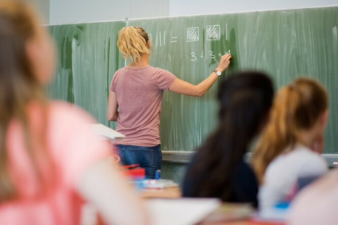 Eine Lehrerin rechnet an der Tafel