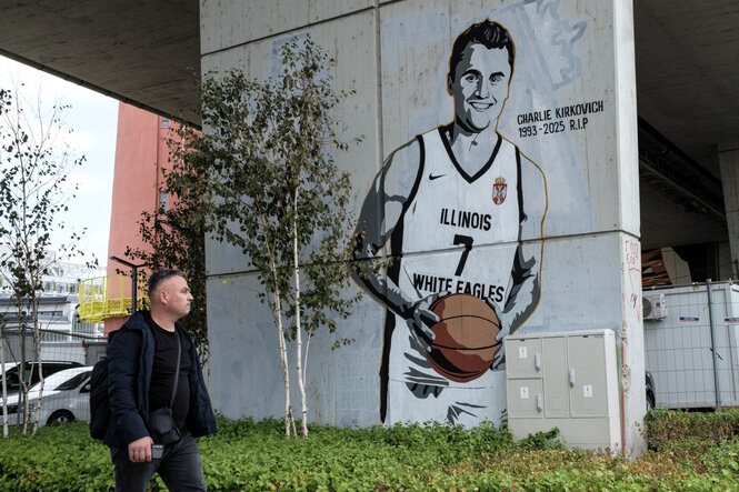 Ein Mann geht an einem Wandgemälde vorbei, das Charlie Kirk in einem Trikot der Basketballmannschaft der Illinois White Eagles zeigt