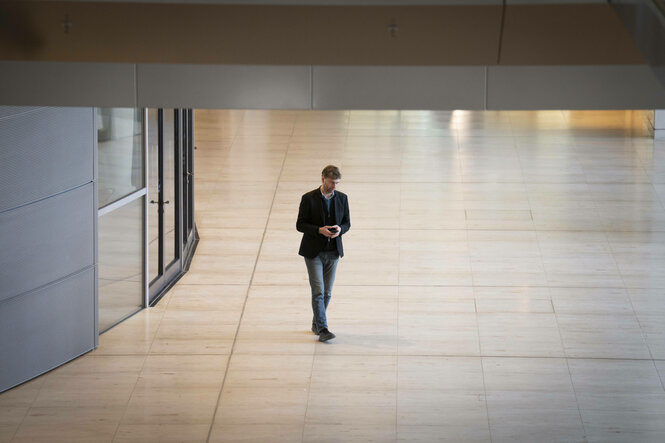 Eine Person läuft an einer Glastür vorbei