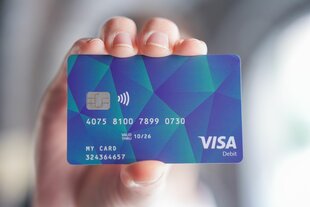 Eine Person hält eine Bezahlkarte für Asylsuchende in der Hand