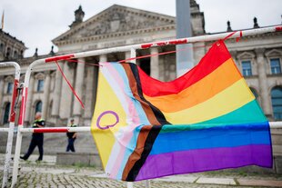 Eine Pride-Flagge hängt vor den Reichtag