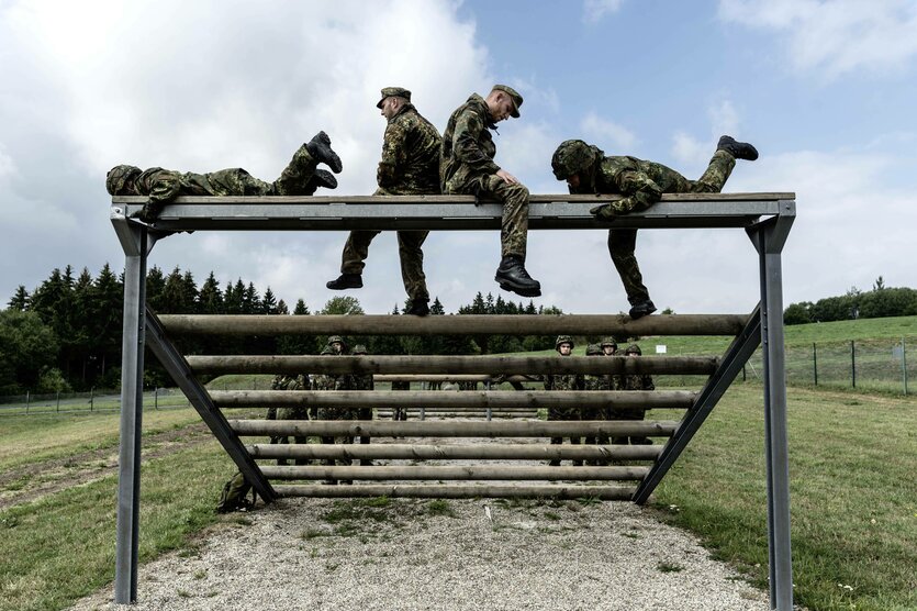 Mehrere Soldaten sitzen und liegen auf einem Geländer