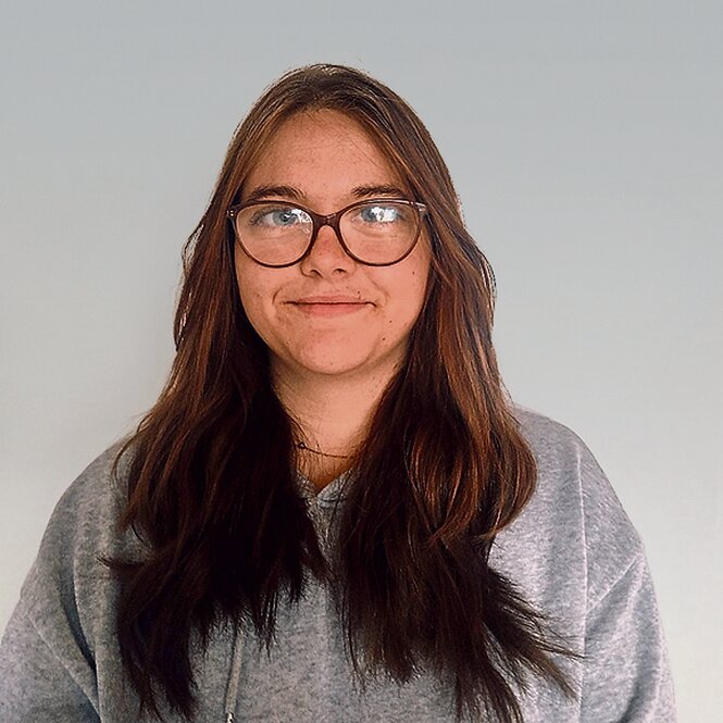 Foto eines Menschen mit Brille und langen Haaren