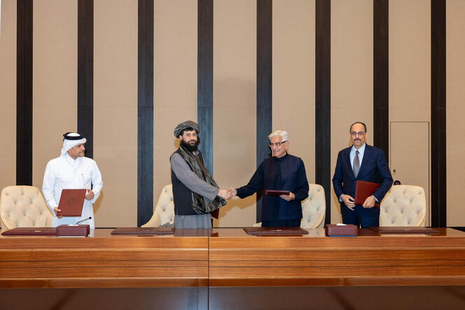 Die Verteidigungsminister beider Länder reichen sich bei der Unterzeichnung der erneuten Waffenruhe am Sonntag in Katars Hauptstadt Doha die Hand