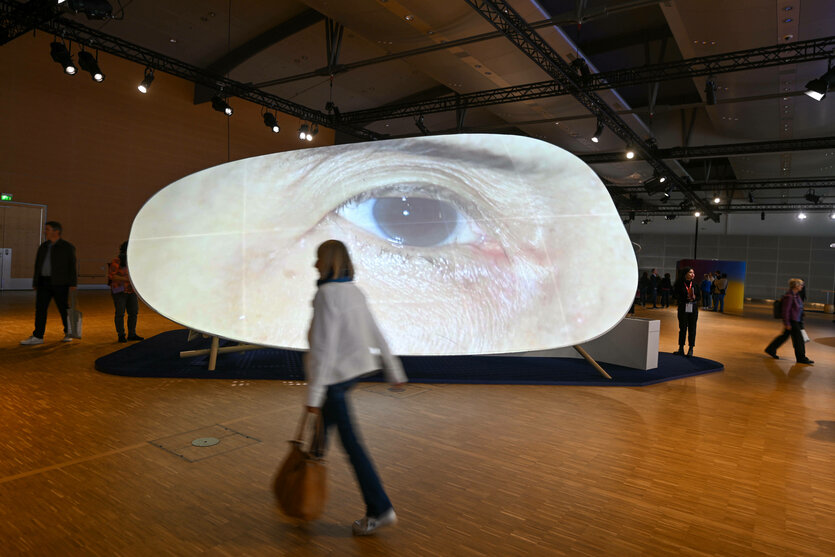Das riesig große Abbild eines menschlichen Auges, projiziert auf eine Leinwand
