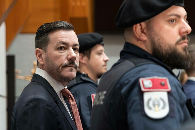 Mann in Anzug zwischen Polizisten