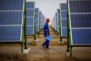 Ein Arbeiter inspiziert Solarmodule auf einer Solarfarm in Dunhuang, 950 km nordwestlich von Lanzhou in der Provinz Gansu.
