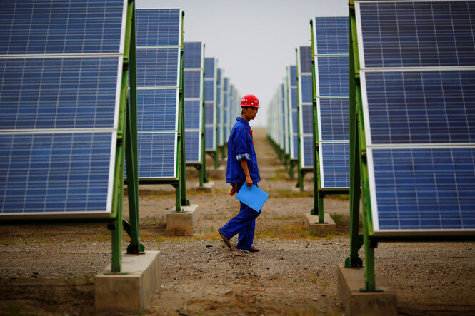 Ein Arbeiter inspiziert Solarmodule auf einer Solarfarm in Dunhuang, 950 km nordwestlich von Lanzhou in der Provinz Gansu.