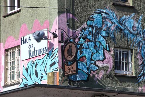 Häuserecke mit Graffiti und Schild "Haus der Kulturen"