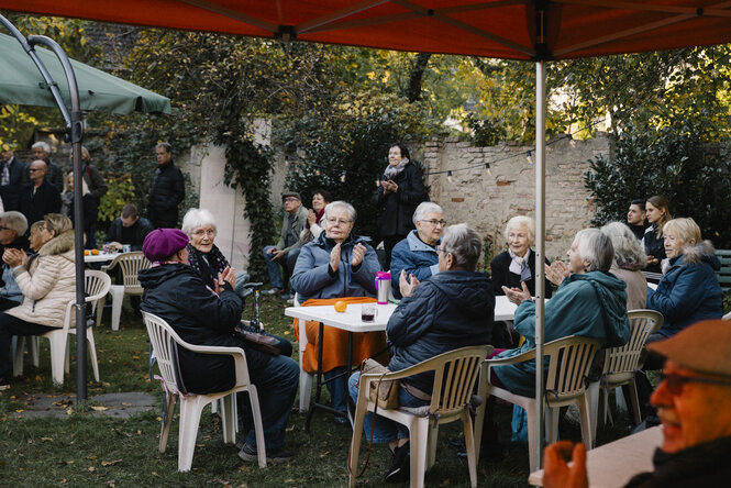 ältere Frauen auf Stühlen in einem Garten