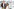 Drei Personen – Austin Butler, Zoe Kravitz und Darren Aronofsky – stehen nebeneinander vor der Stadtkulisse Londons mit hohen, modernen Gebäuden und einem Riesenrad im Hintergrund. Sie blicken in die Kamera und tragen unterschiedliche Outfits in hellen und gedeckten Farben.