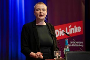 Kim Sophie Bohnen steht vor dem Parteilogo der Partei "Die Linke"