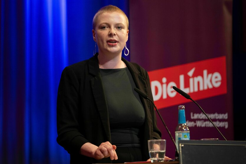 Kim Sophie Bohnen steht vor dem Parteilogo der Partei "Die Linke"