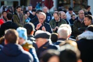 Friedrich Merz steht in einer Menschenmenge und spricht