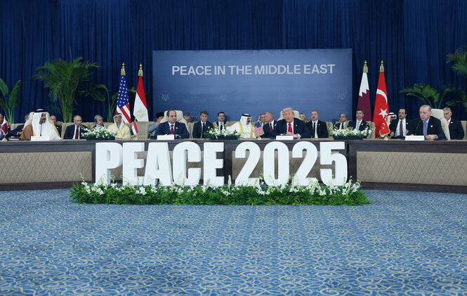Vertreter verschiedener Staaten sitzen an einem Tisch, an dem steht: "Peace 2025"