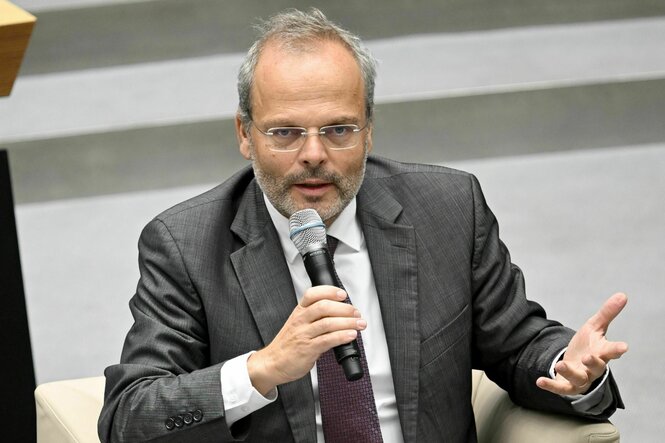 Ein Mann im grauen Sakko spricht in ein Mikrofon