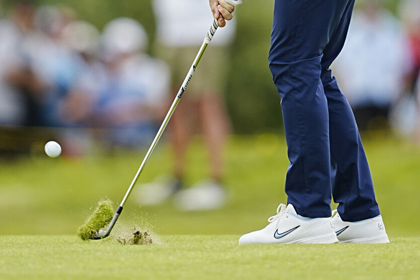 Beine eines Mannes mit Golfschläger beim Golfen