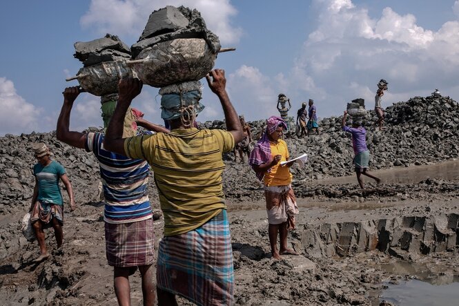 Männer schleppen Sandsäcke