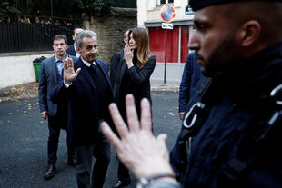 Nicolas Sarkozy winkt seinen Anhängern zu, als er mit seiner Frau Carla Bruni-Sarkozy sein Haus verlässt.