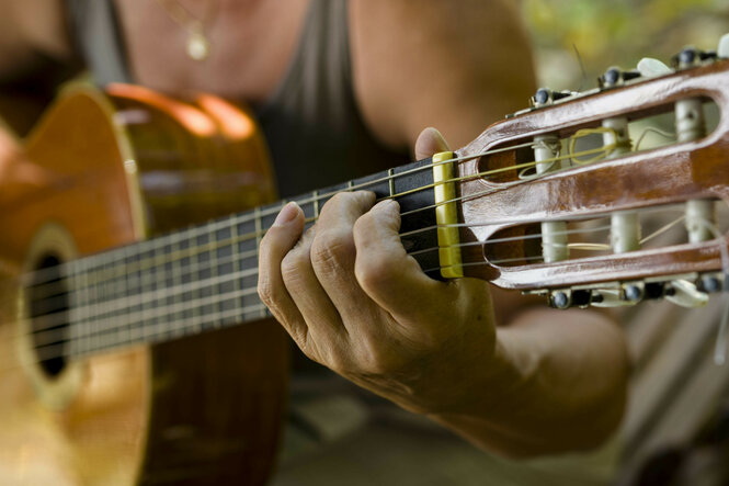 Hände an einer Gitarre.