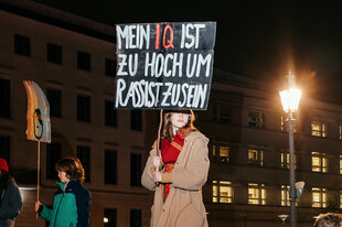 Frau hält ein Schild