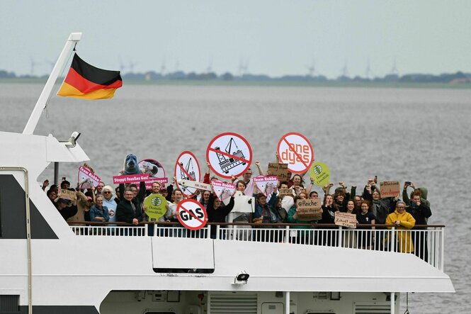Aktivisten der Klimabewegung Fridays for Future mit Protestschildern auf dem Schiff MS Katamaran vor Borkum