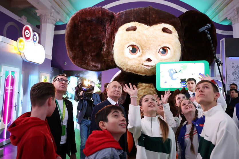 Jugendliche und Walidmir Putin mit einem großen Stofftier auf der Russischen Expo