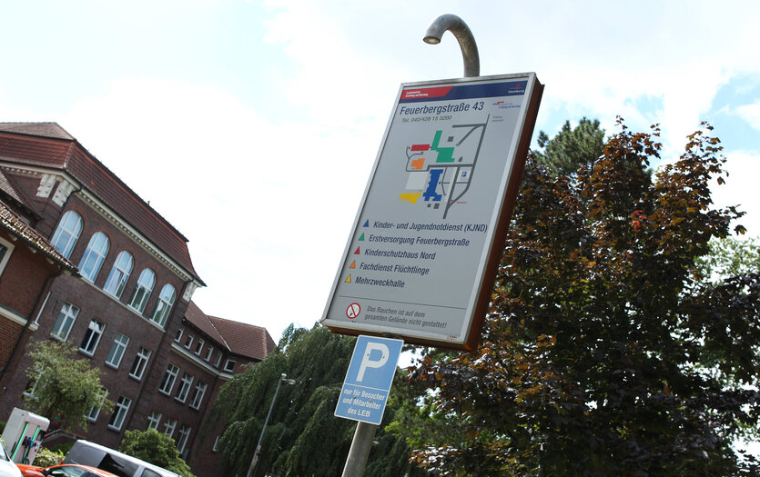 Ein Backsteingebäude schief aufgenommen, im Vordergrund ein Schild, auf dem steht "Kinder. und Jugendnotdienst"