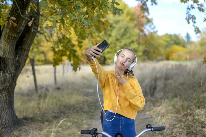 Teenagerin mit Smartphone und Fahrrad, Brandenburg
