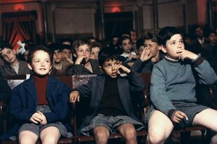 Kinder sitzen fasziniert und angespannt in einem Kinosaal