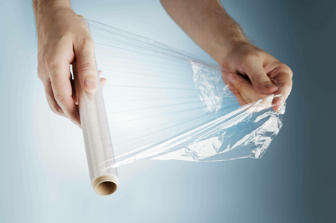 Hände halten Frischhaltefolie