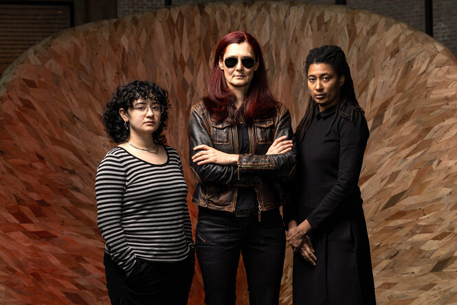 Das Trio Eliza Salem, Angelika Niescier und Tomeka Reid steht vor einem flächige Gebilde aus kleinen Holzteilen.