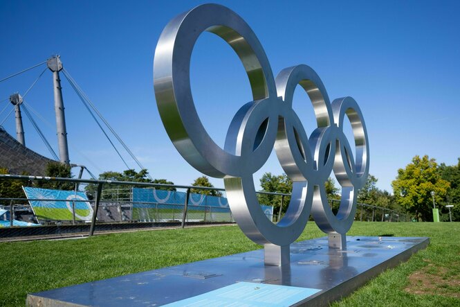 Die Olympischen Ringe vor der zeltdachkulisse des Olympiastadions in München