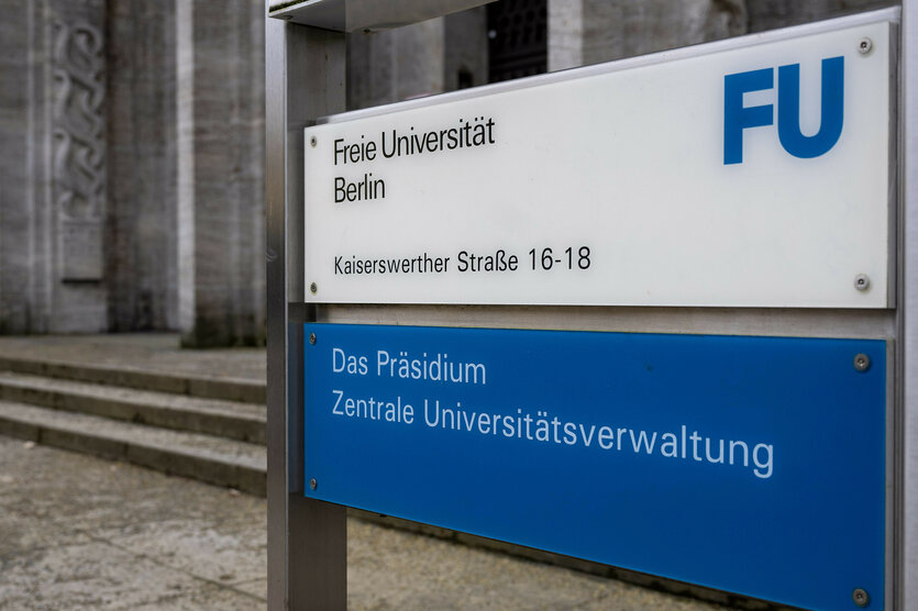 Ein Aufsteller mit der Aufschrift «Freie Universität Berlin. Das Präsidium. Zentrale Universitätsverwaltung» steht vor einem Uni-Gebäude.