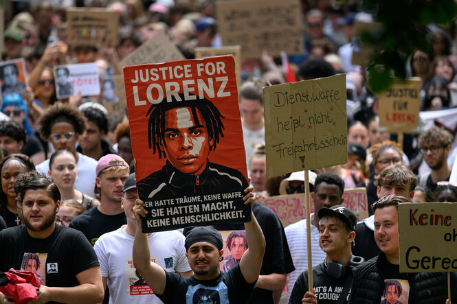 Teilnehmer einer Demonstration "Gerechtigkeit für Lorenz" halten ein Bildnis des Toten in die Höhe
