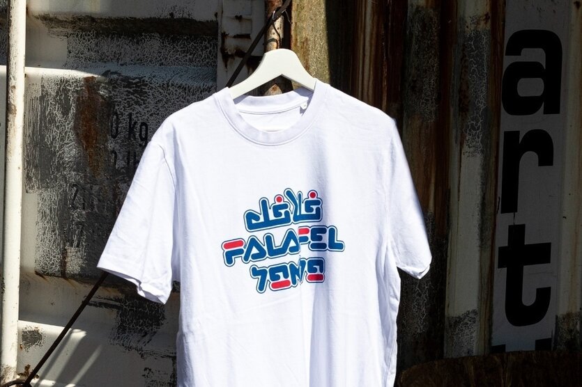 Ein T-Shirt mit dem Wort "Falafel" auf Arabisch, Englisch und Hebräisch
