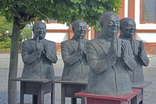 Bronzeskulptur zeigt vier Männer beim Klatschen