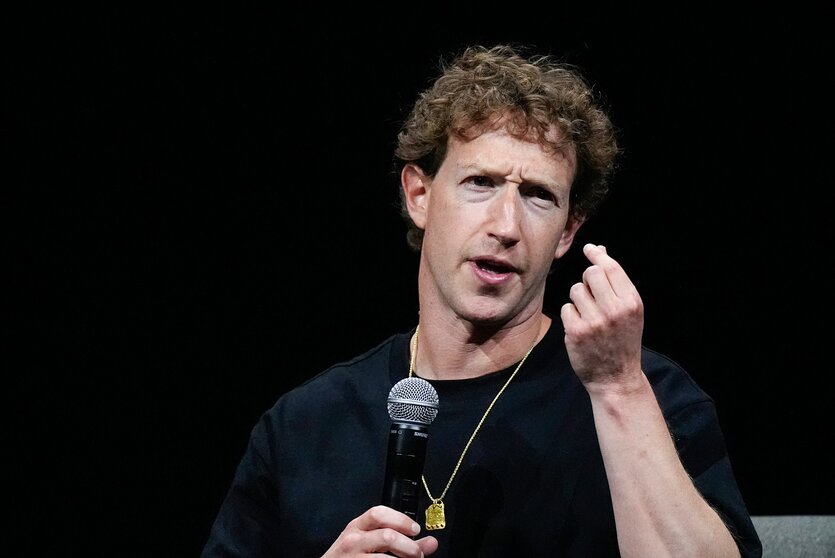 Meta-Chef Mark Zuckerberg spricht mit unzufriedenem Blick in ein Mikro.