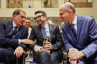 Drei Männer sitzen nebeneinander