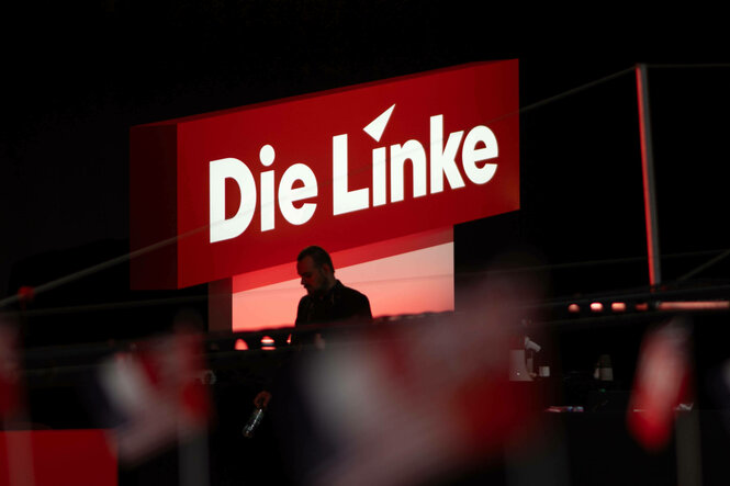 Das Logo der Partei Die Linke leuchtet im Hintergrund