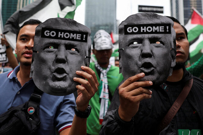 Go Home! steht auf Trump-Masken von Protestierenden