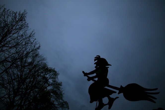 Schattenriss einer Hexe vor einem wolkenverhangenen Himmel