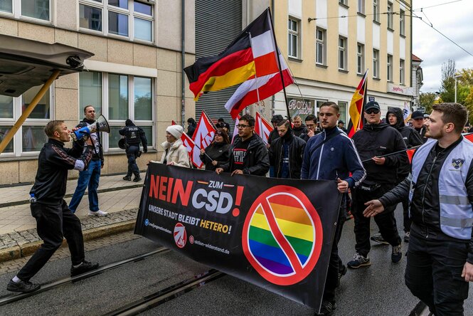 Menschen mit Deutschlandfahnen halten ein Transparent mit der Aufschrift "Nein zum CSD" und "Unsere Stadt bleibt Hetero"
