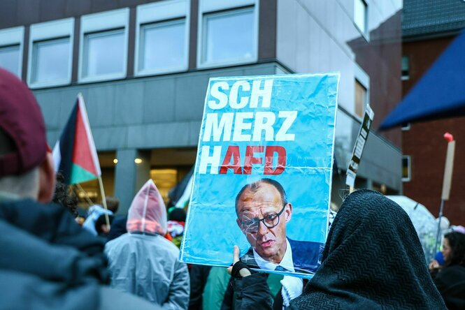 Ein Plakat mit dem Konterfei von Friedrich Merz und dem Slogan "SchmerzhAfD"