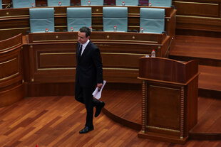 Albin Kurti geht durch ein leeres Parlament