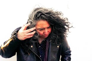 Porträt einer Frau in Lederjacke von schräg oben, der Wind bewegt ihr Haar